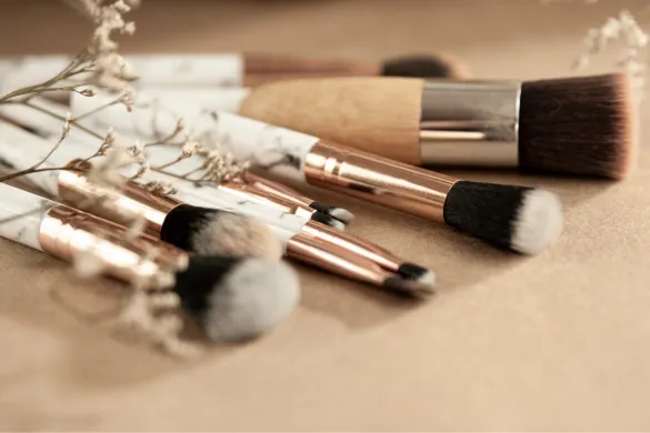 A set of makeup brushes arranged on a surface.