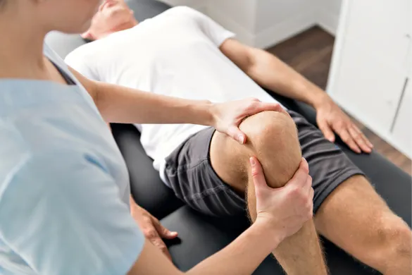 A physical therapist examining a patient's knee.
