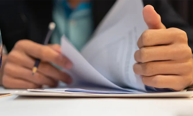A person reviewing documents on a clipboard.