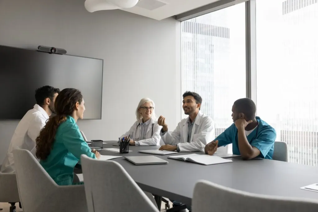 A group of medical professionals having a meeting around a conference table in an office.